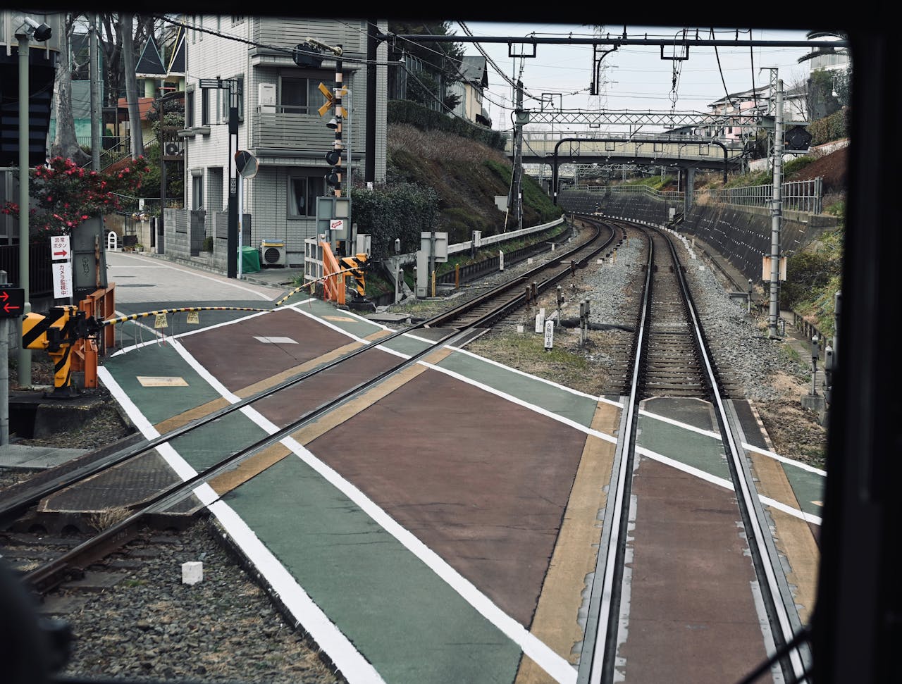View of a railway crossing in urban area with multiple tracks and buildings.